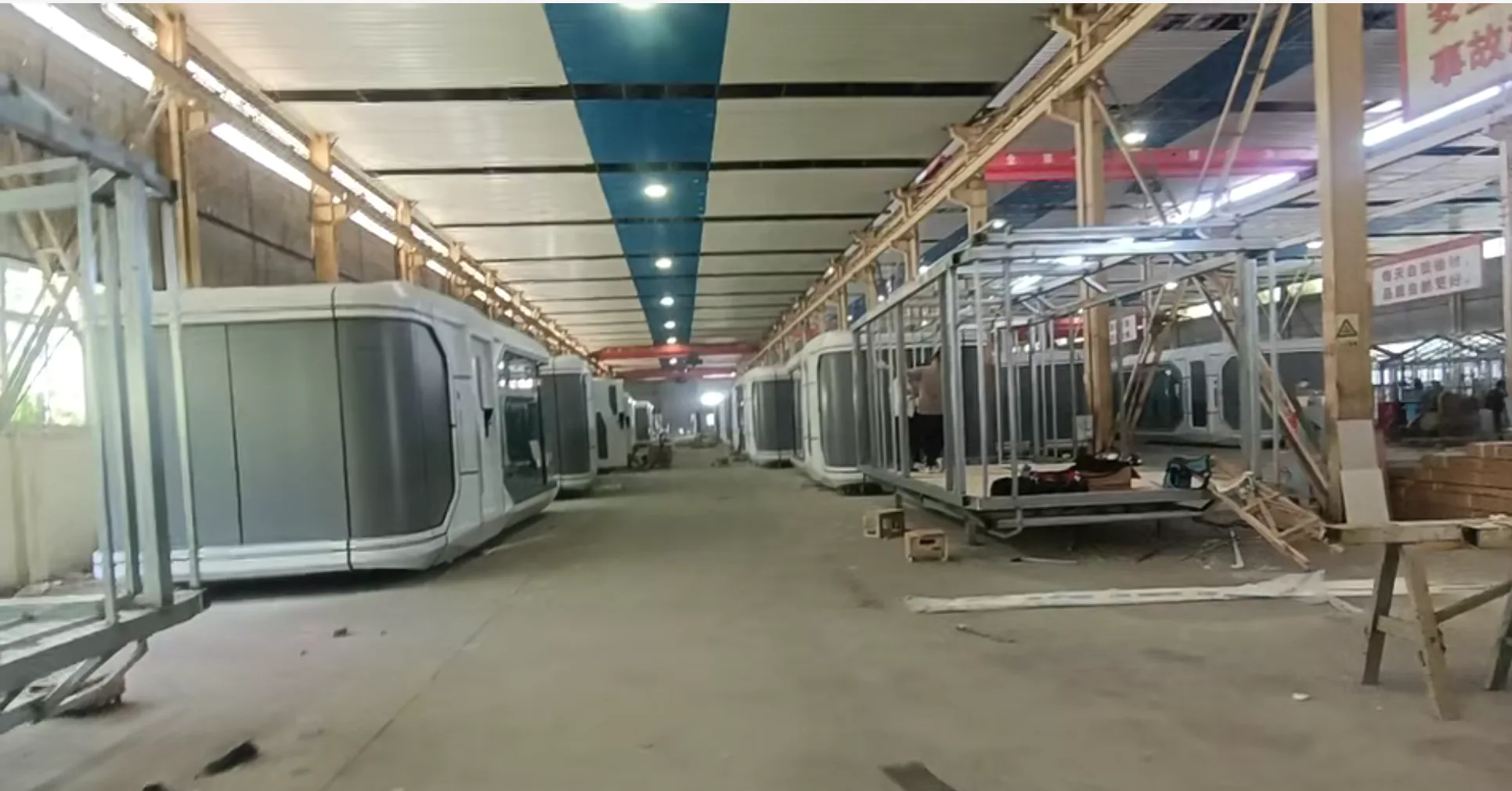 Curved modular building shells progressing through factory production
