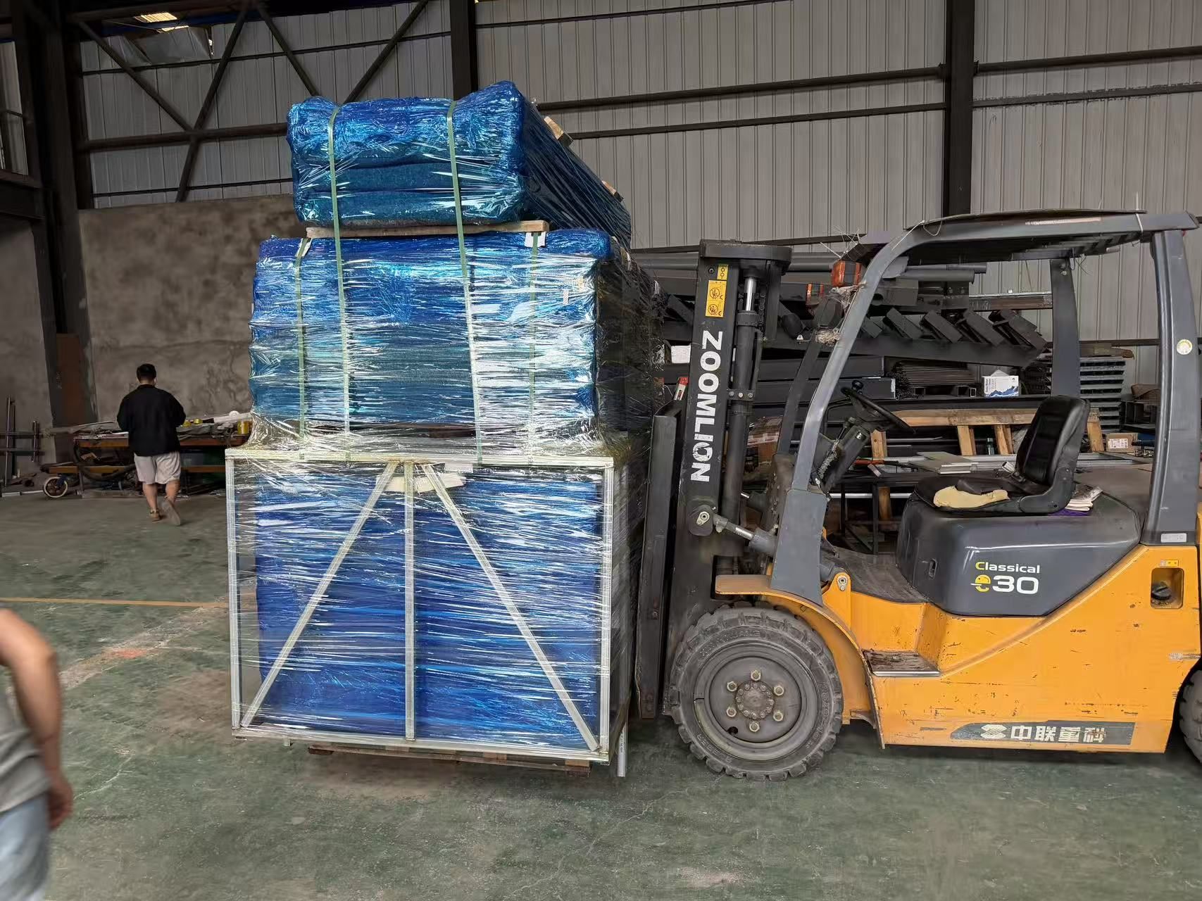 Forklift moving a packed prefab cabin module